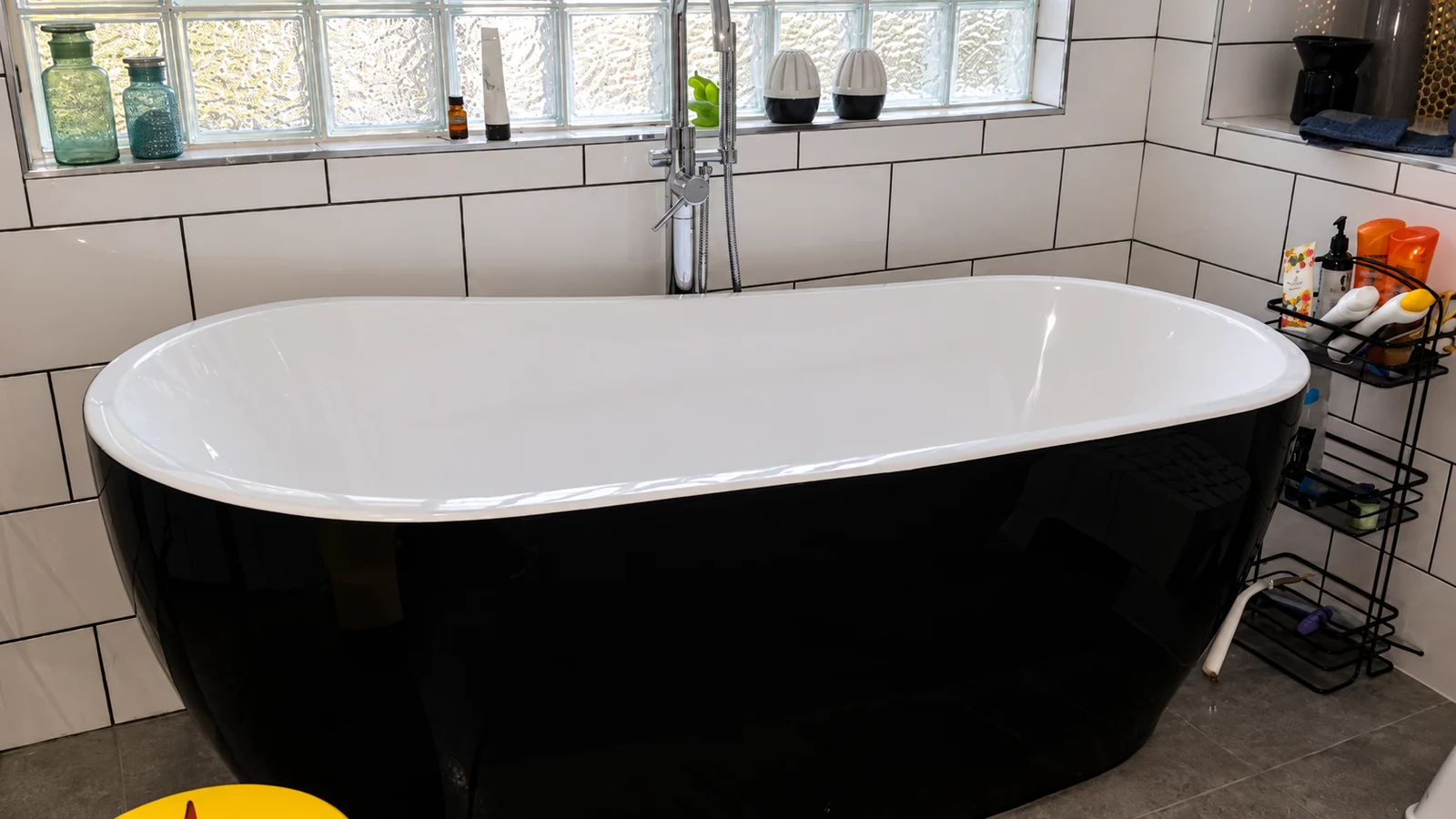 Freestanding bathtub in a tiled bathroom.